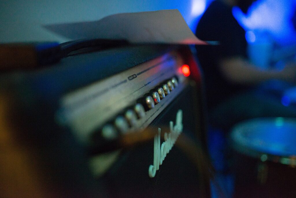 Piccolo amplificatore portatile appoggiato al suolo accanto a un cavo e a un microfono