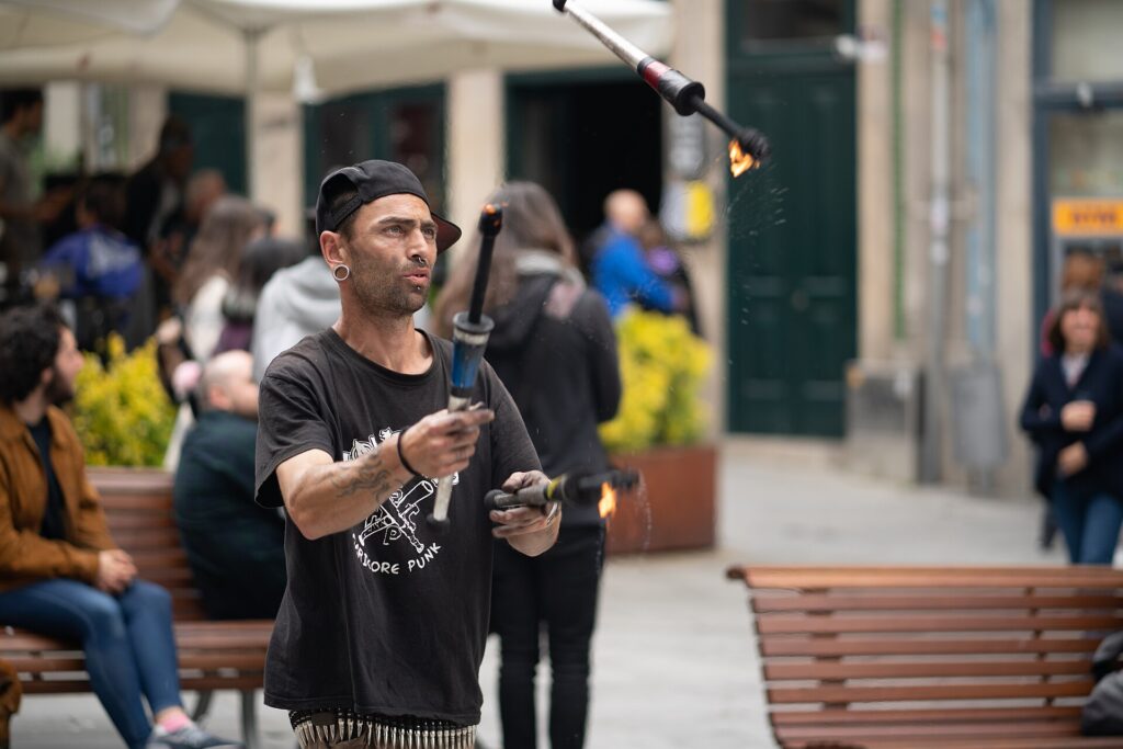 Giocoliere che si esibisce in una piazza davanti a un piccolo gruppo di passanti
