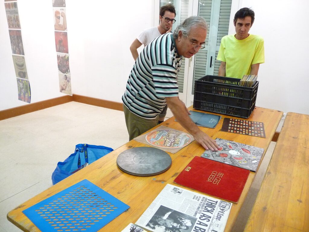 Copertine di dischi in vinile allineate dentro una cassa di legno in un negozio
