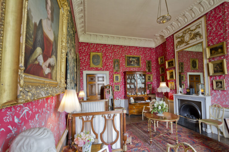 Specchio di camerino circondato da lampadine accese con appunti infilati nella cornice