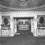 Ingresso di un teatro con le porte a vetri aperte e il banco della biglietteria illuminato