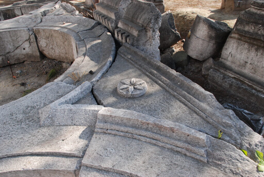 Portico con colonne di pietra e pavimentazione in lastre lungo una via del centro