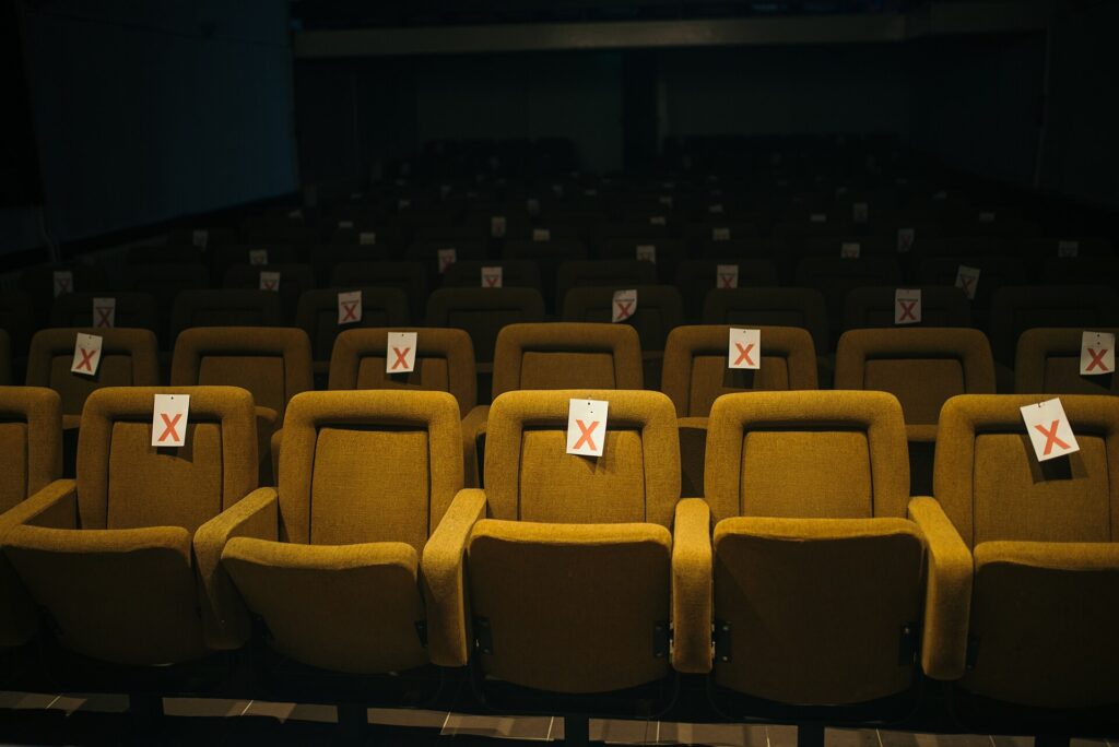 File di poltrone rosse vuote in una sala teatrale vista dal palco