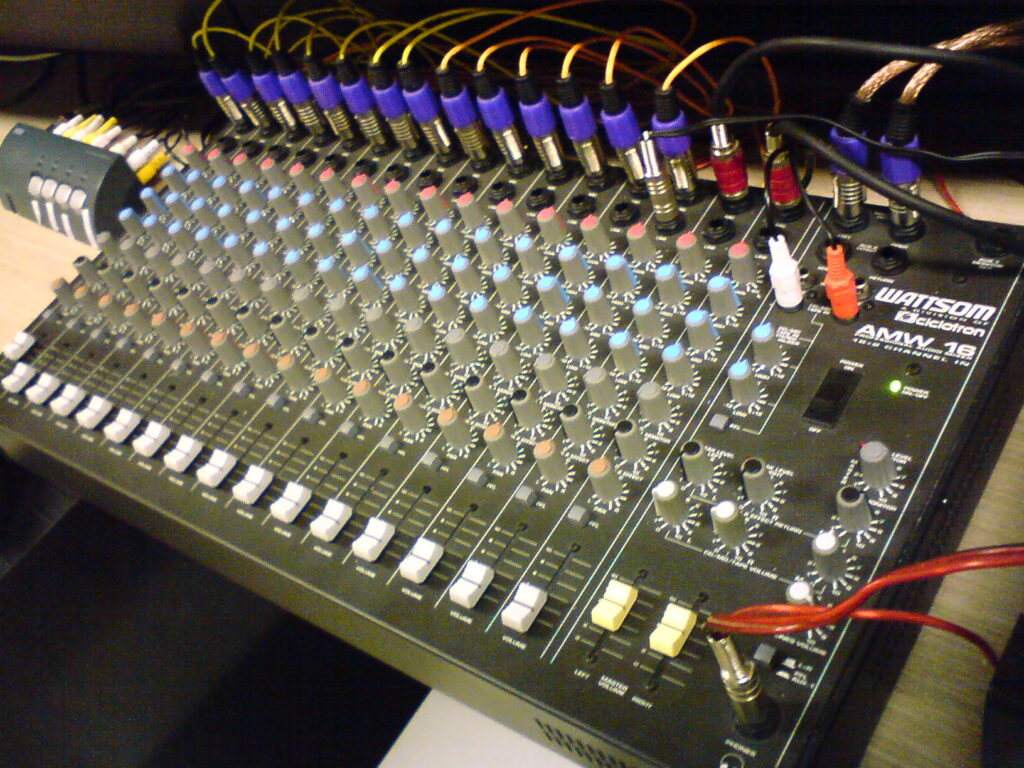 Console da disc jockey con manopole e cursori vista dall'alto durante una serata