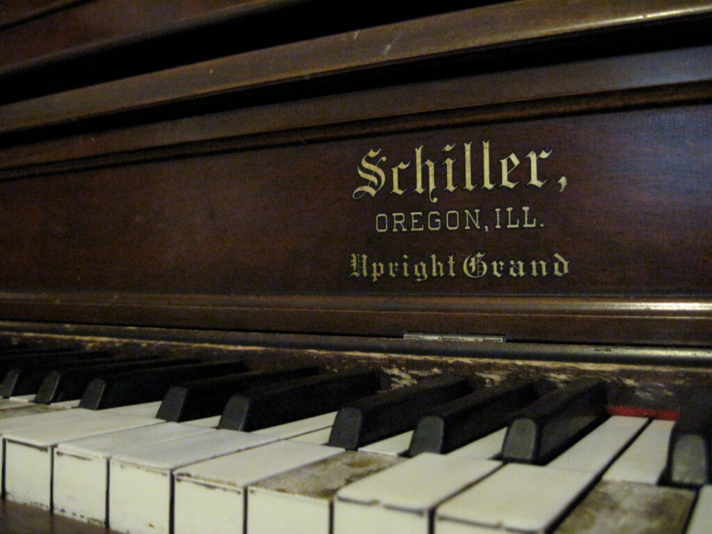 Tastiera di un pianoforte ripresa da vicino con le mani ferme sui tasti bianchi